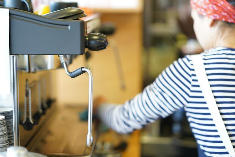 A barista near a coffee machine.