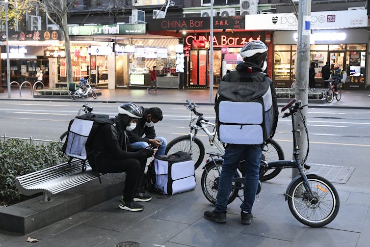 Delivery riders in Melbourne's deserted CBD