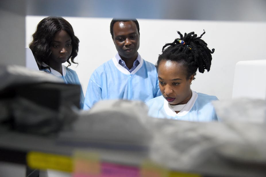 Africa Centre of Excellence for Genomics of Infectious Diseases laboratory manager and colleagues analyse samples in a laboratory 