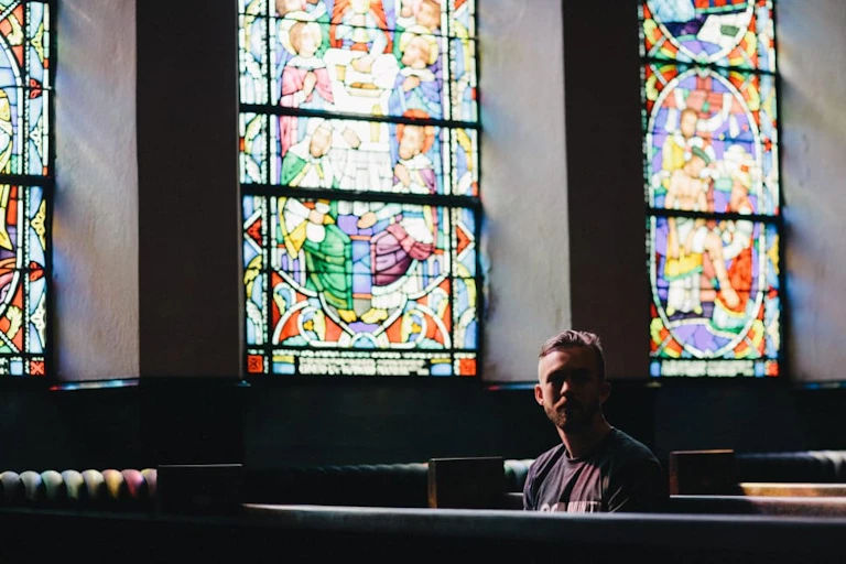Un homme assis sur un banc d'église