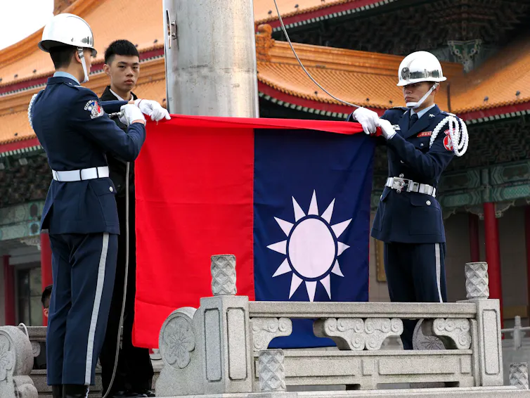 Men lower the Taiwanese flag.