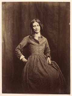 A photograph of a female patient of Surrey County Lunatic Asylum, facing the camera.