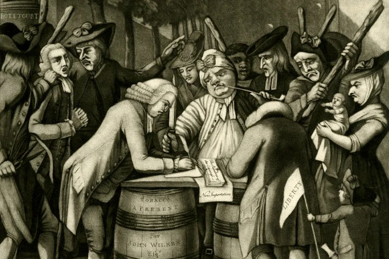 A group of people assembled around a barrel signing a document.
