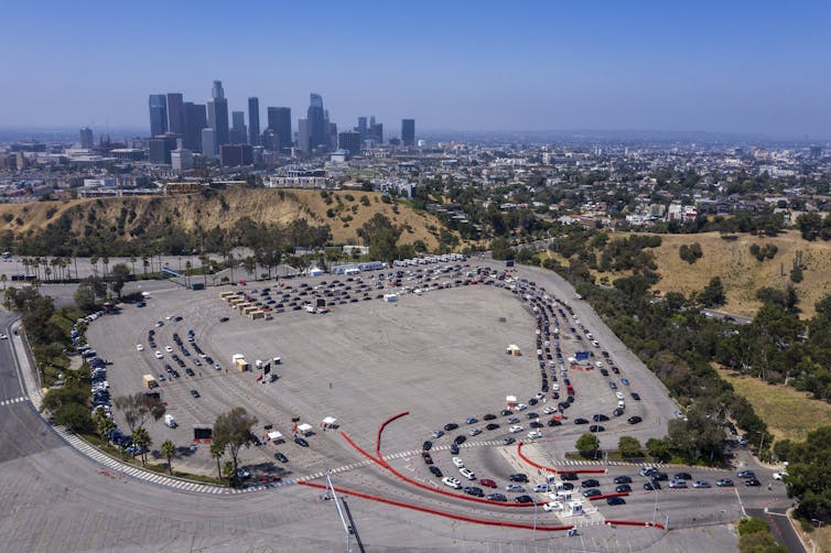 An aerial image of a long line of cars waiting for a COVID-19 test at Dodger stadium in Los Angeles