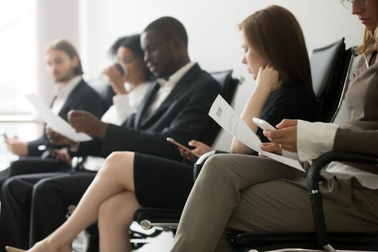 People in suits, sitting, waiting for job interviews