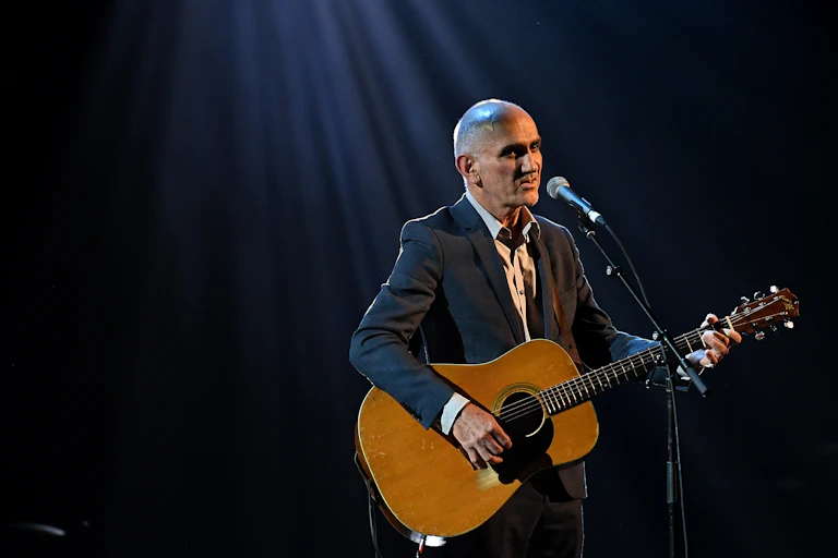 Paul Kelly performing on stage