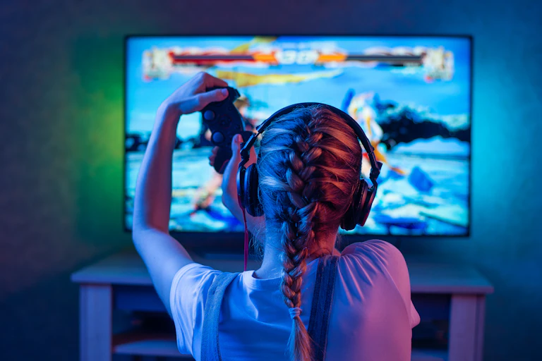 Una joven juega a videojuegos en una pantalla de televisión.