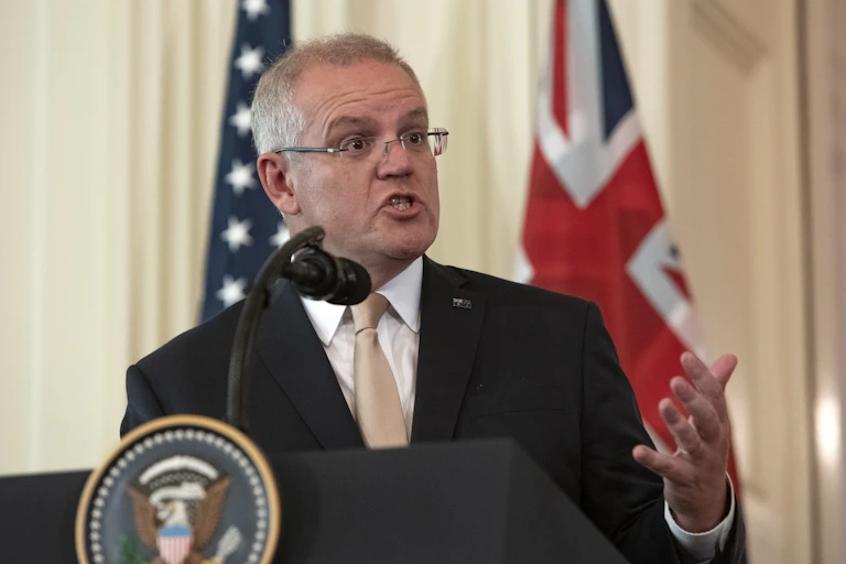 Scott Morrison delivers a speech in front of an American and Australian flag