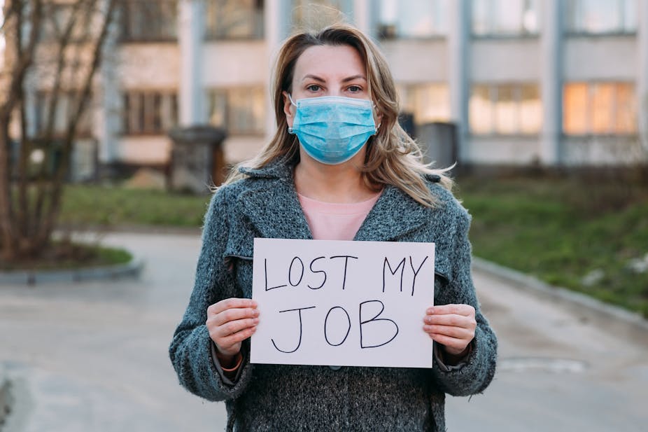 Woman wearing face mask holds sign saying "lost my job".