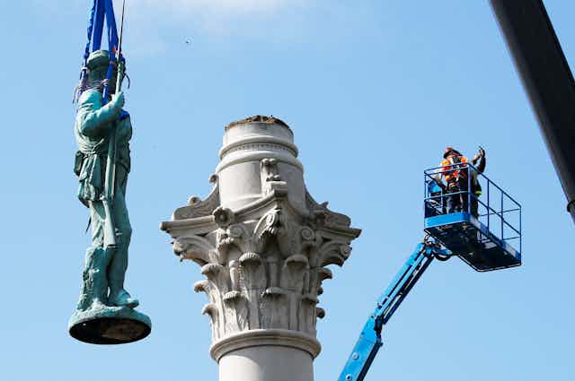 A statue is removed from its pedestal.