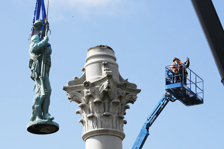 A statue is removed from its pedestal.