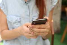 A young woman is seen reading on her phone.