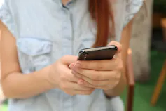 A young woman is seen reading on her phone.