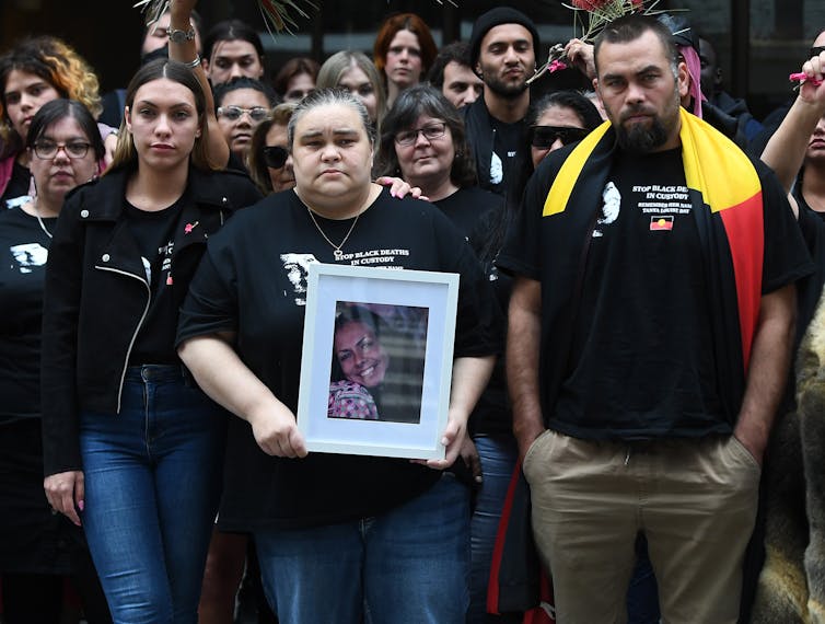 Tanya Day's children holding a picture of their mother.