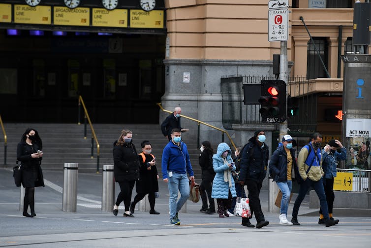 People walking near Flinders Street Station wearing masks during COVID-19
