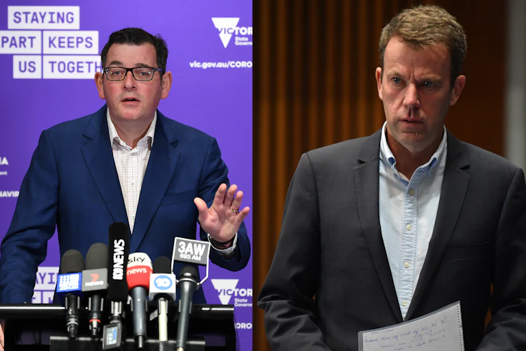 Daniel Andrews on the left, behind the microphone; Dan Tehan on the right, holding speaking notes