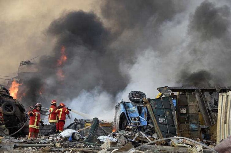 Firefighters on the ground battle a blaze.