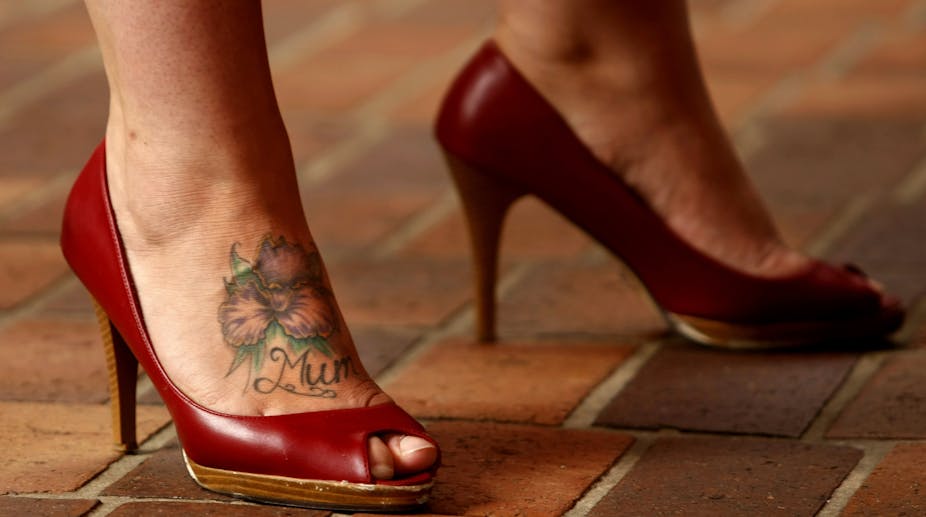 Woman in a pair of high heeled red shoes