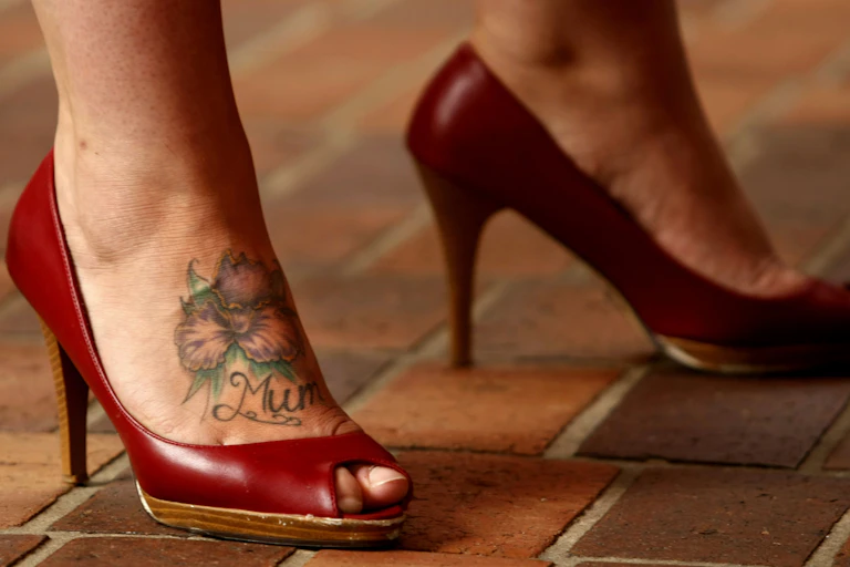 Woman in a pair of high heeled red shoes