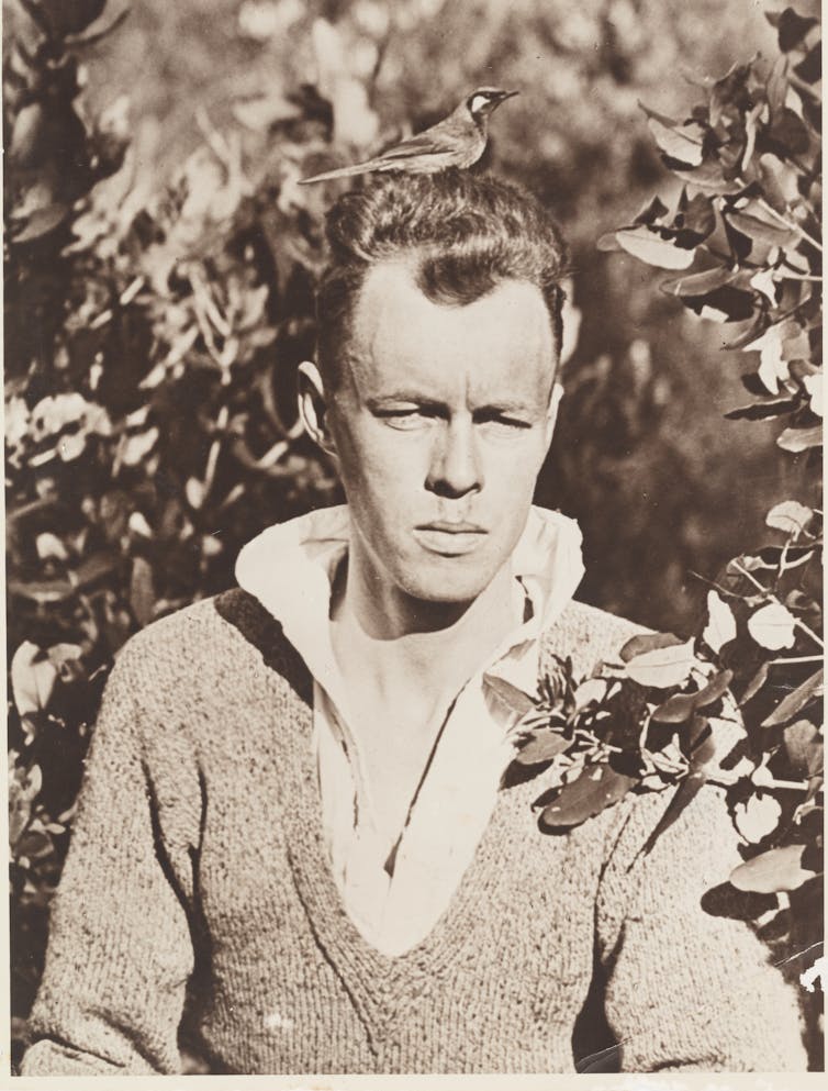 Keith Hindwood in black and white, with a White-eared Honeyeater on his head