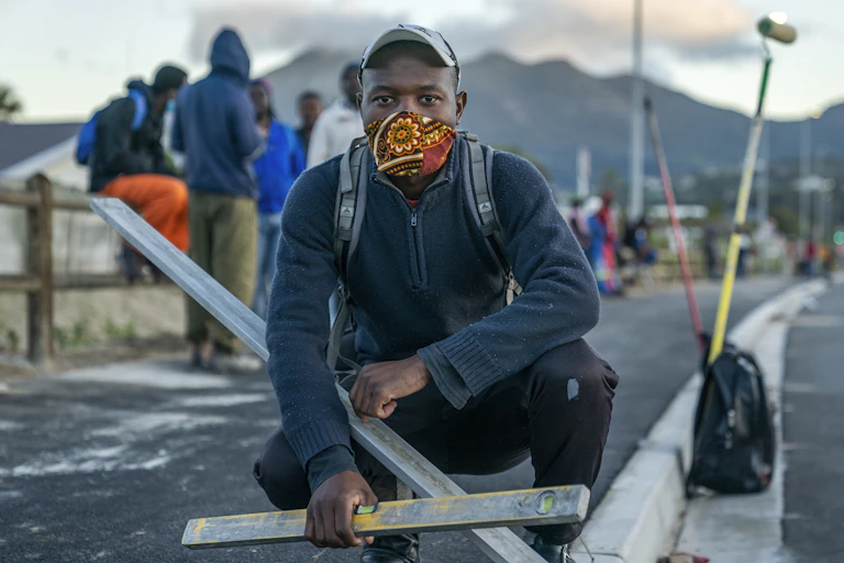 A South African decorator working in the informal sector stands by the roadside waiting for work.