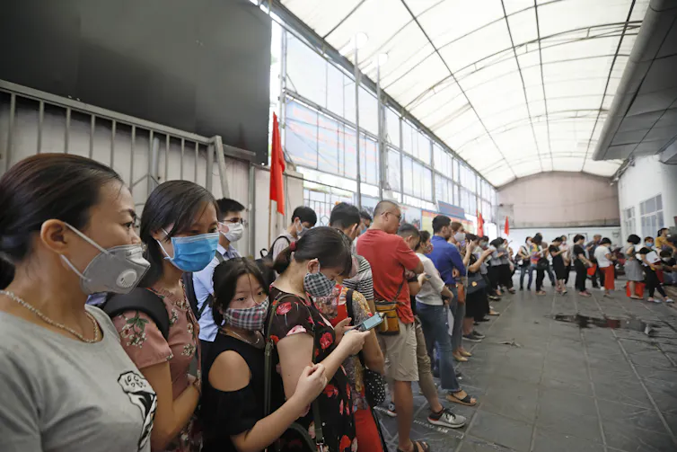 People in Vietnam queue to receive unemployment benefits.