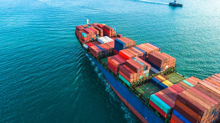 Aerial view of ship loaded with shipping containers in ocean