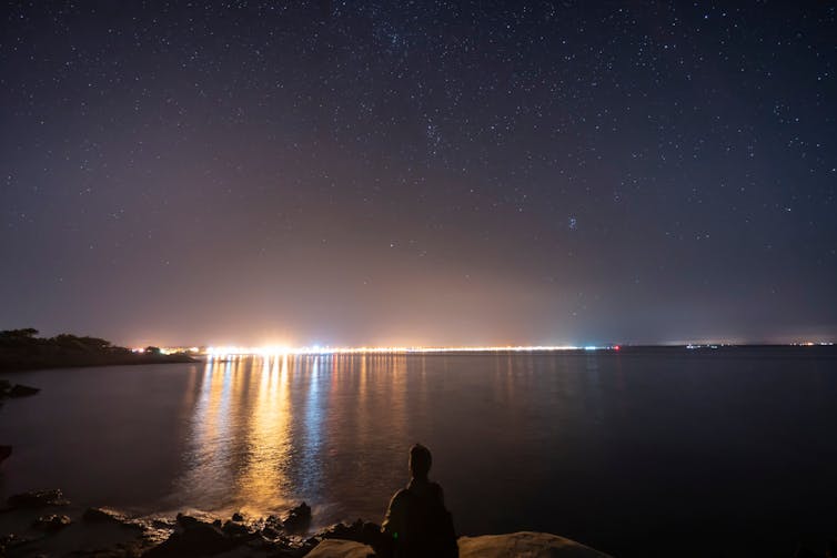 The Mallorca skyline on the horizon with light extending out over the sea.