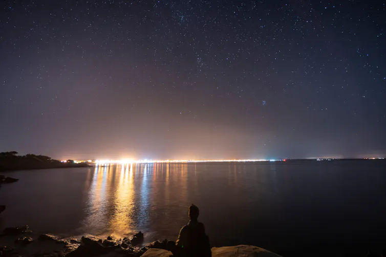 The Mallorca skyline on the horizon with light extending out over the sea.
