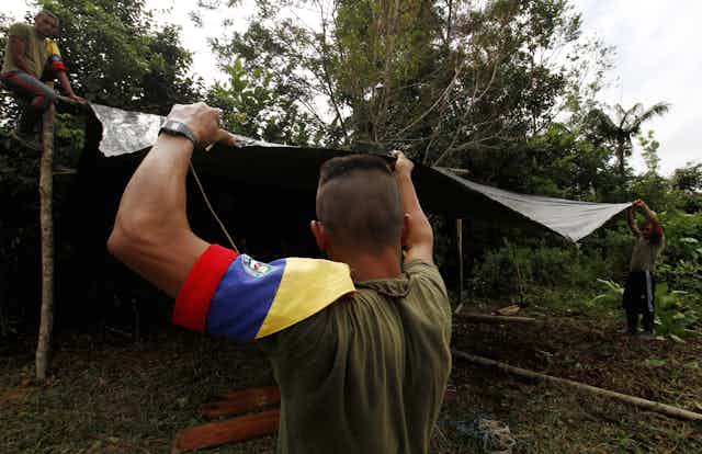 Three men in Colombia constructing a shelter.
