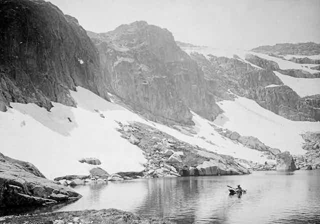 A man rows a boat on Blue Lake in 1906