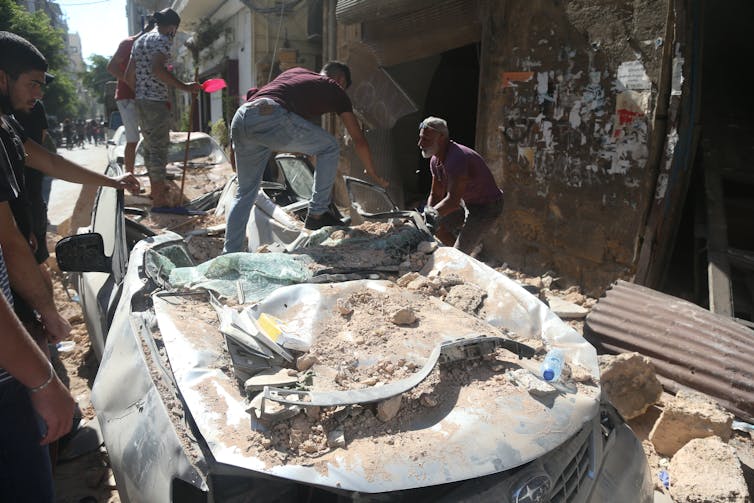 Lebanese men clears rubble, one day after the explosion at the Beirut Port.