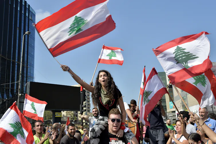 Lebanese protestors wave Lebanon flags.