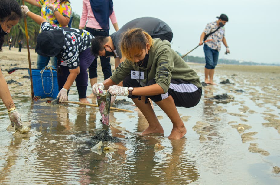 Young female volunteer clearing beach of plastic.