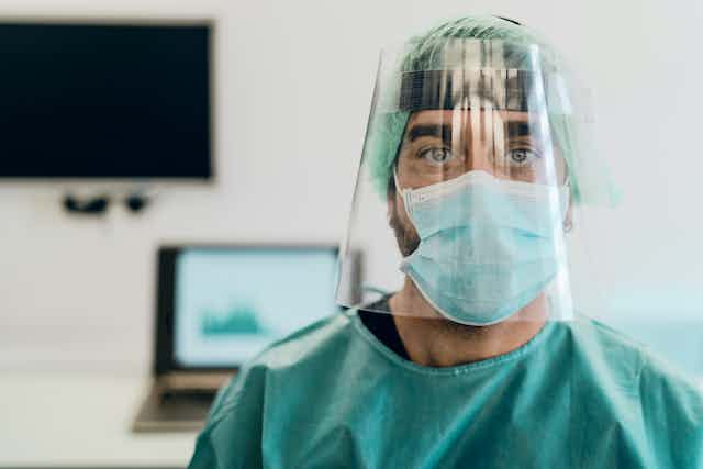Doctor wearing PPE face mask and visor