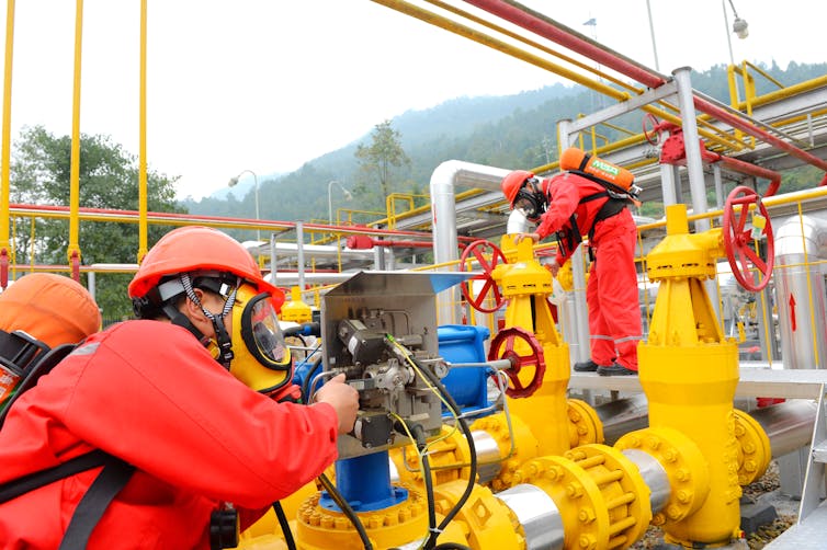 Technicians examine pipes at a shale gas facility in China