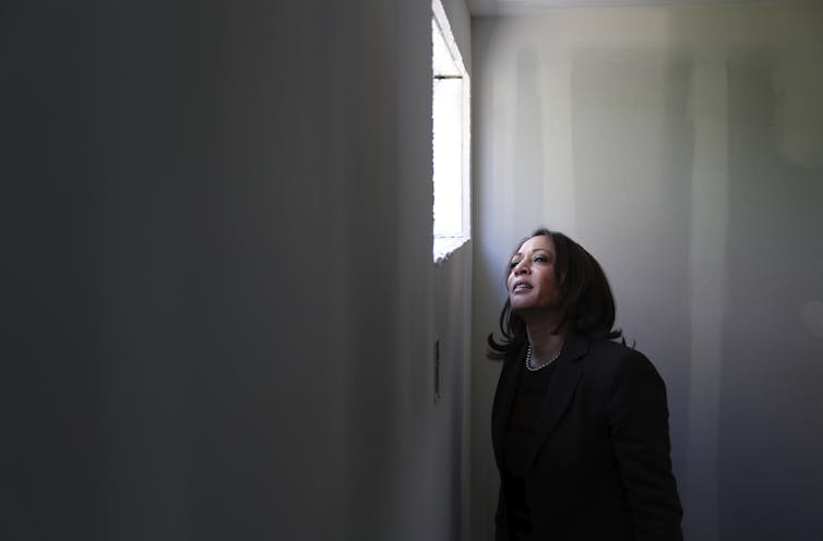 Sen. Kamala Harris peers out of a window at Veterans Village in Las Vegas.