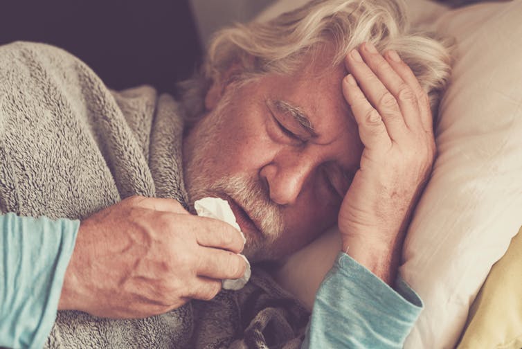 Elderly man in bed with a fever.