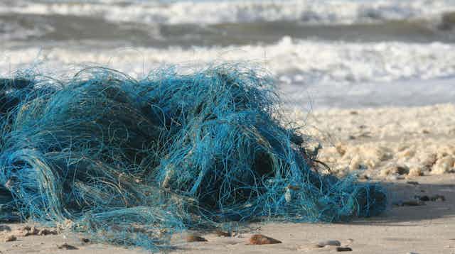 A blue fishing net washed up on the beach