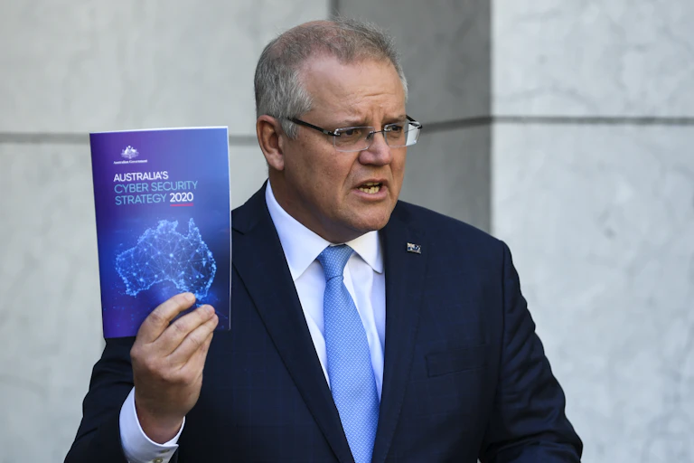 Australian Prime Minister Scott Morrison holds up a copy of Australia's Cyber Security Strategy 2020