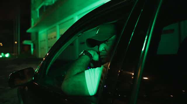 Man at night in car window