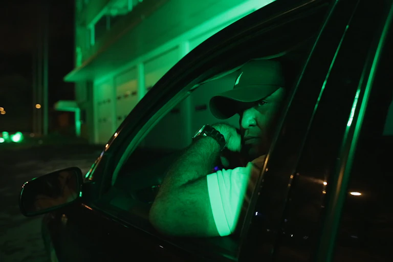 Man at night in car window