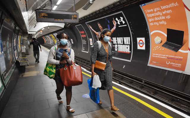 Two women wearing face masks on London Underground