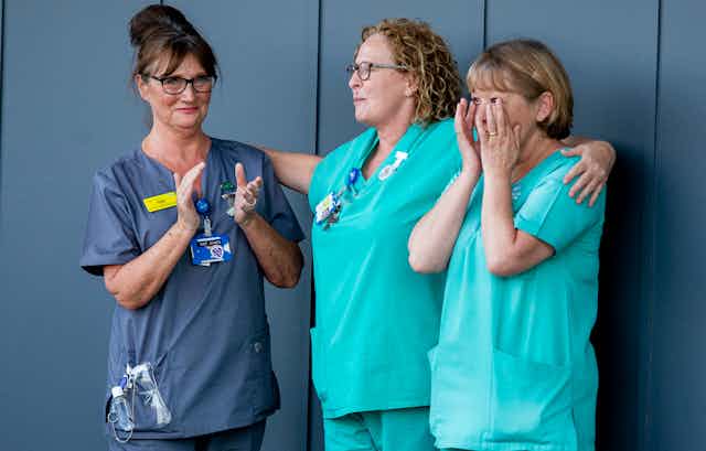 Three women healthcare professionals outside an NHS hospital