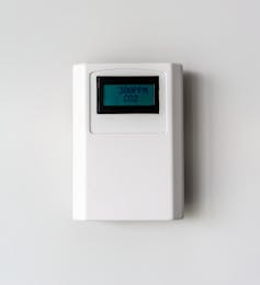 A carbon dioxide meter mounted on a white wall showing a reading of 300 parts per million.