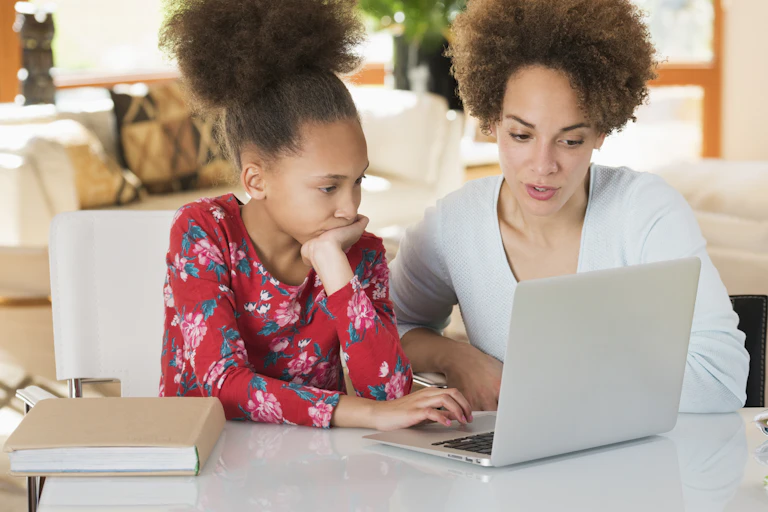 stock photo of mother and daughter looking at a laptop