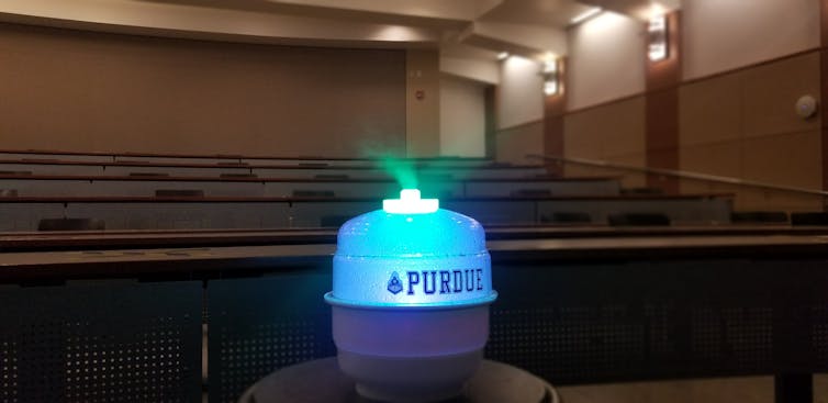 A humidifier-like device dispensing mist in a classroom