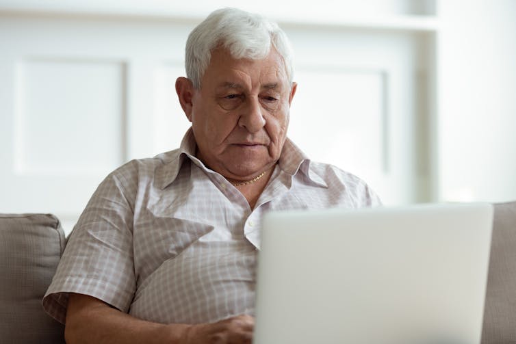 A man looks at a laptop computer screen.