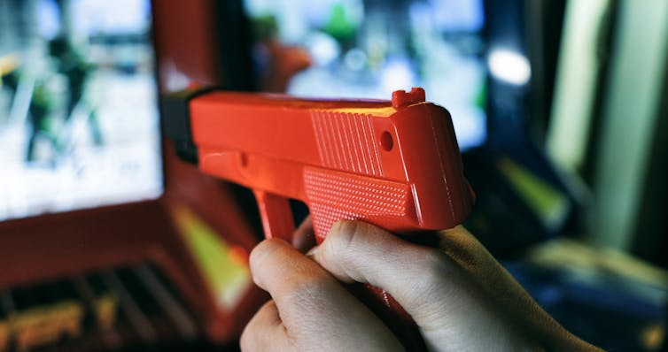 Plastic arcade game gun pointed at screen.