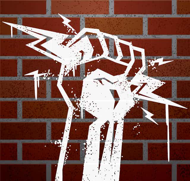 stencil of fist holding lightning bolts with brick background